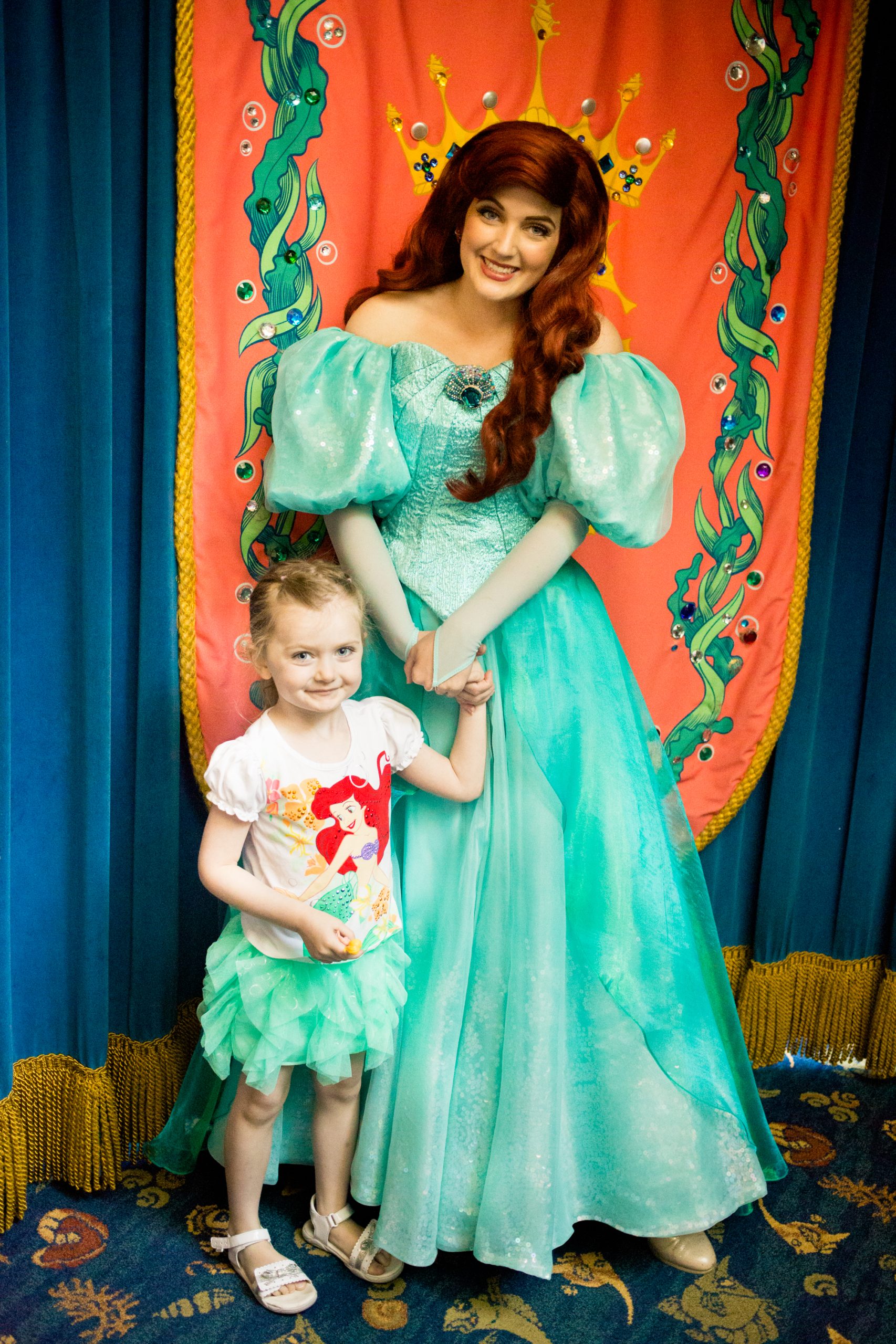 A young girl poses with Ariel.