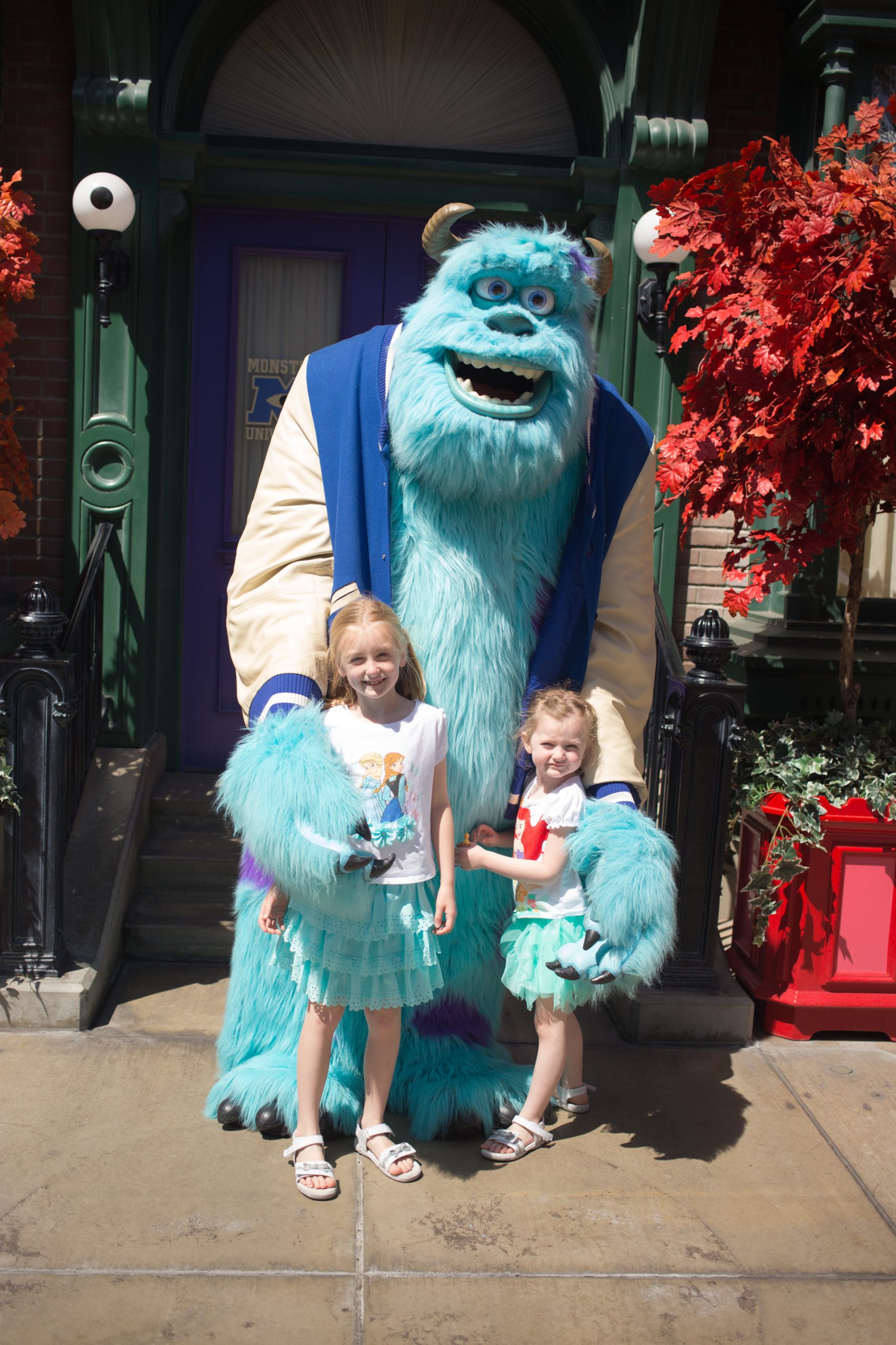 Two young girls pose for a picture with Sully.