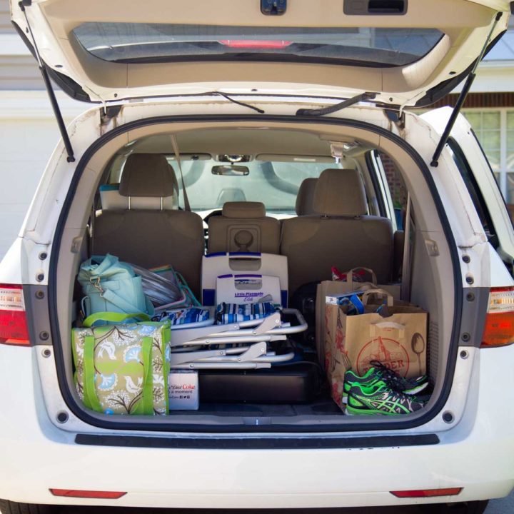 The back of a mini van is open so you can see all the items packed for a family vacation.