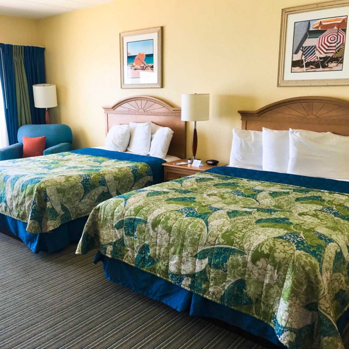 A pair of full-size beds in a hotel room.