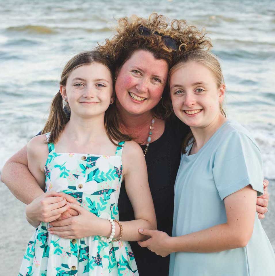 Tiffany Dahle poses for a picture on the beach with her two daughters.