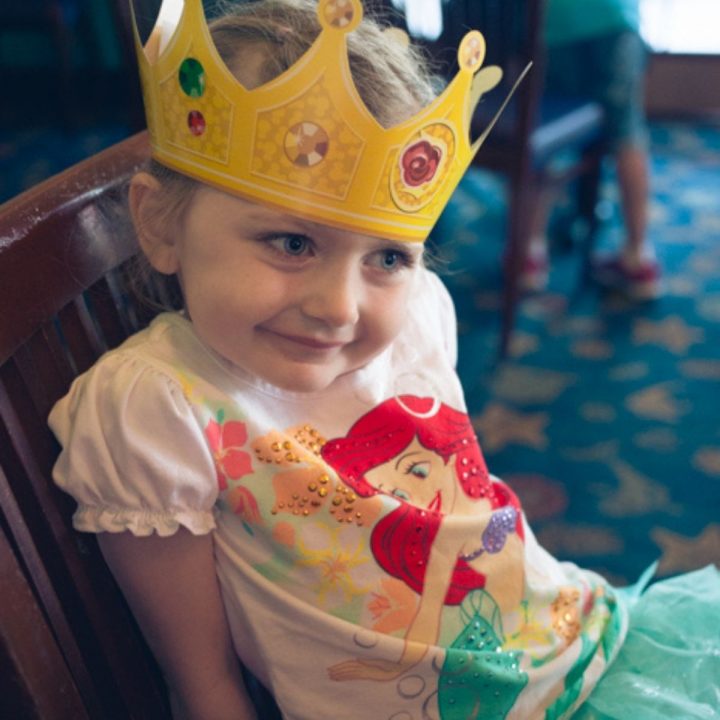 A young Ariel fan wears a paper princess crown.