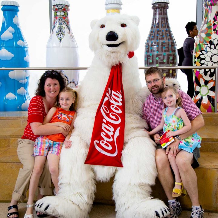 A family poses for a photo with the Coca Cola Bear at the Coca Cola Museum.