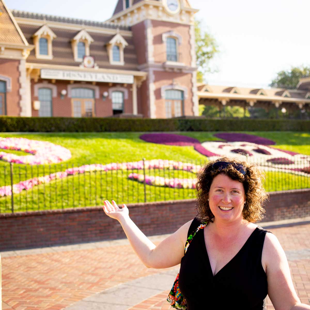 A mom stands outside Disneyland in California.