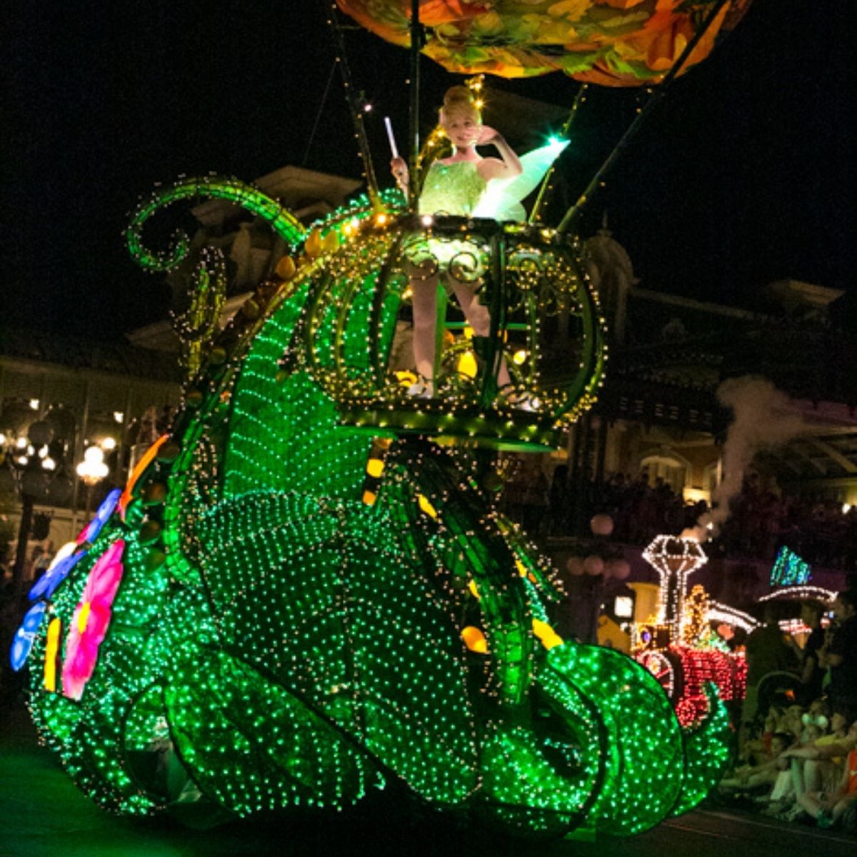 Tinkerbell is on a light-up float as part of the Disney evening parade.