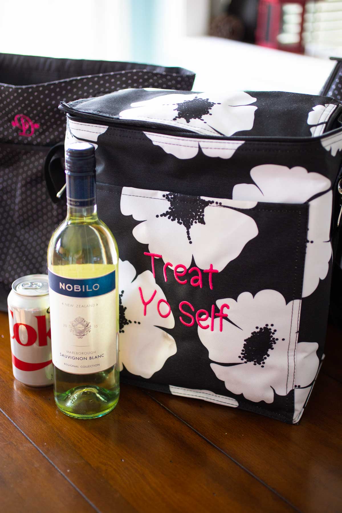 A softsided cooler tote bag has a Diet Coke and a bottle of wine