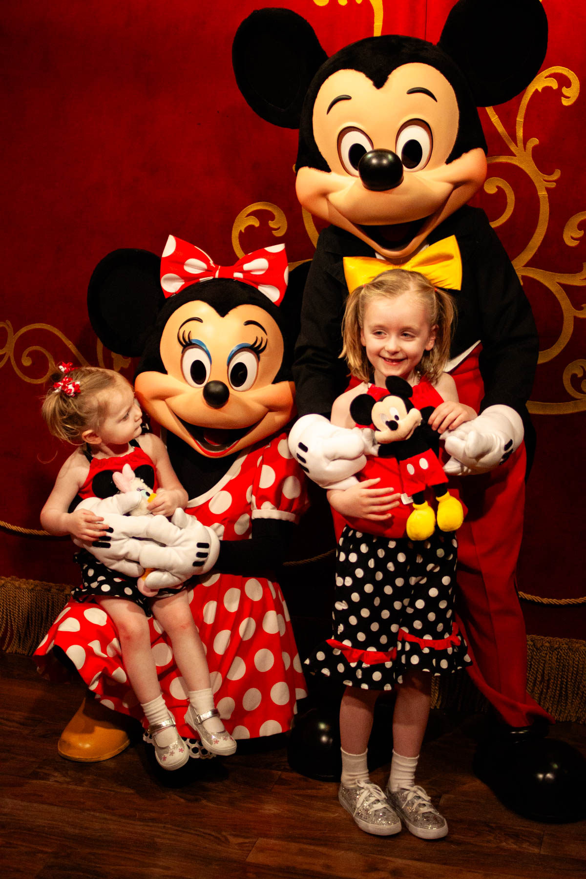 Two young girls visit Mickey and Minnie Mouse at Walt Disney World.