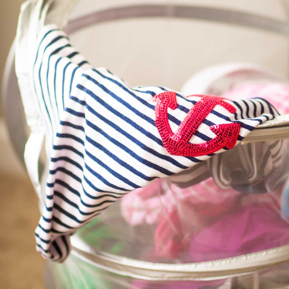 A travel laundry basket has a shirt hanging out.