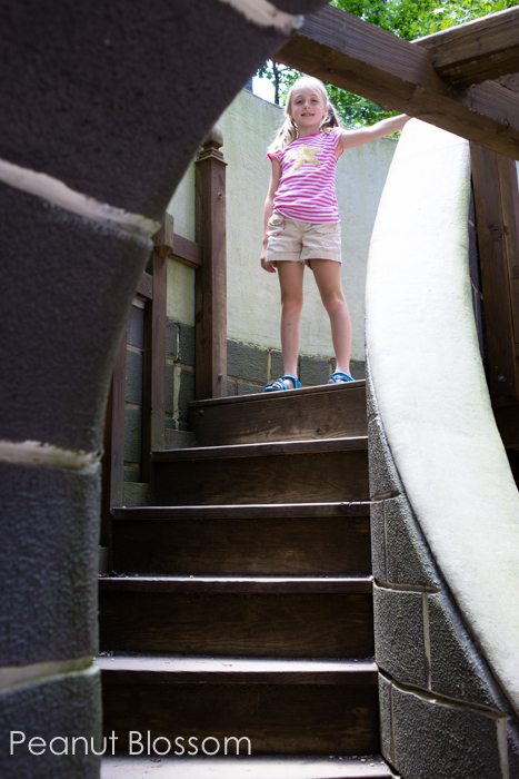 A young girls tands at the top of the steps looking down.