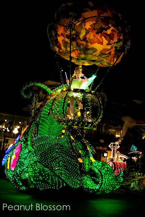 The glowing float featuring Tinkerbell rides down Main Street at Disney World.