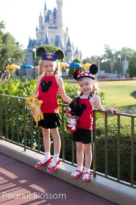 Renting camera gear for vacation | Peanut Blossom Two girls dressed in Mickey ears stand in front of the Disney Castle.