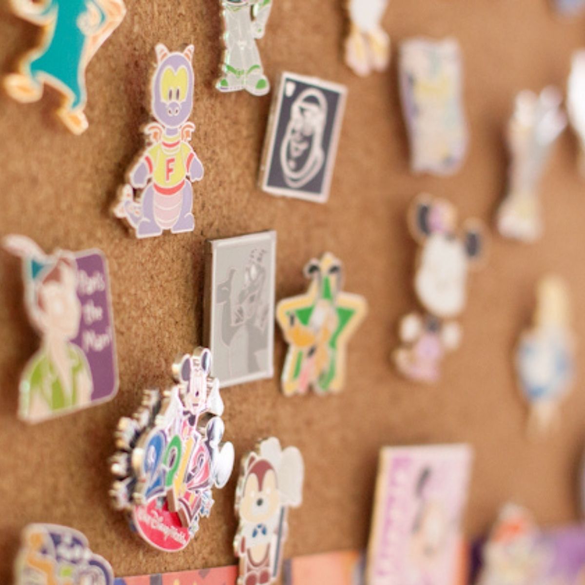 A close-up view of Disney pins on a corkboard.