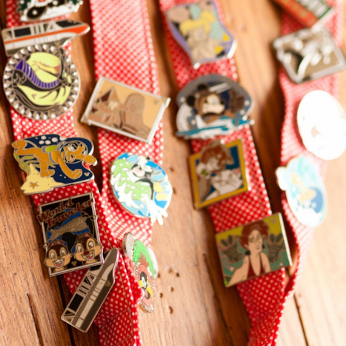 Two red and white polka dot lanyards have Disney pins attached.