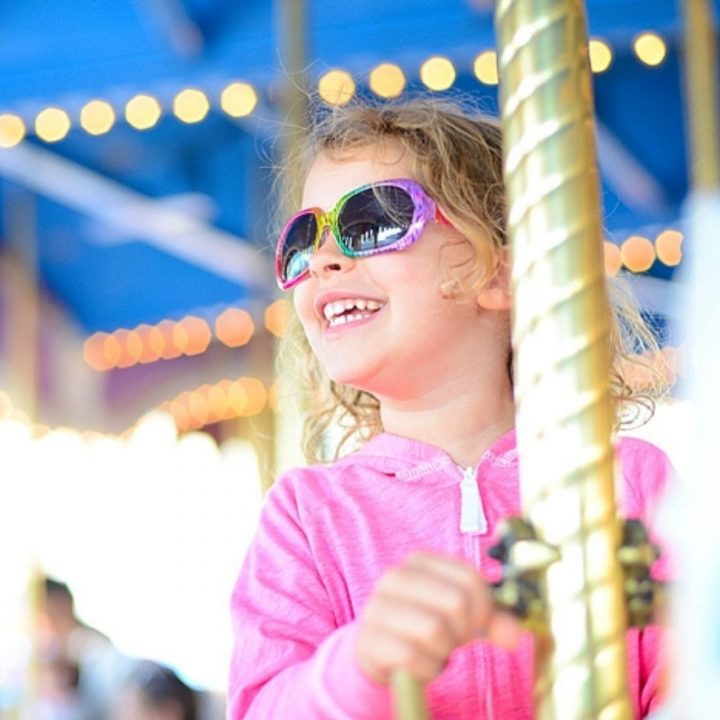 A young girl rides the carousel at Disney World.