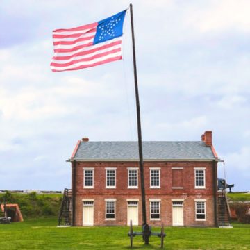 A historical building with an American flag out front at the Fort Clinch State Park.