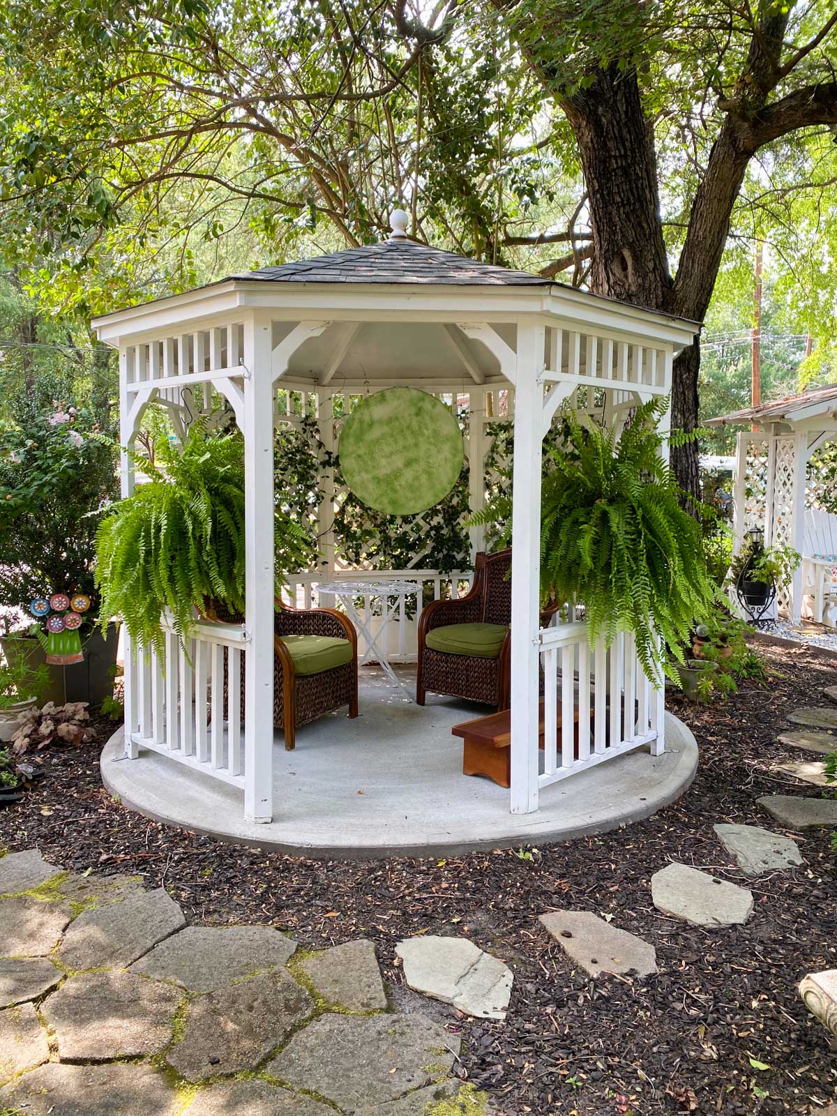 The front yard has a large covered gazebo with hanging ferns.