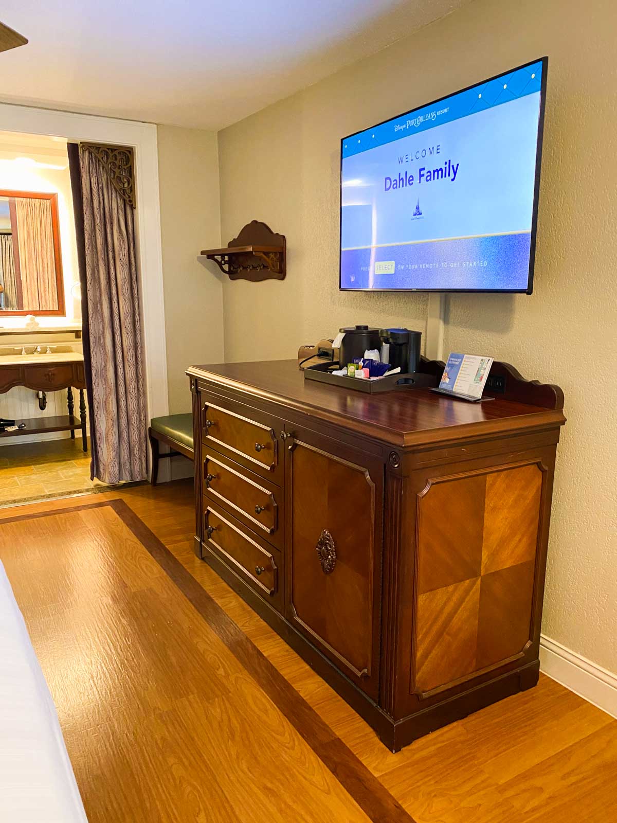 The welcome message is on the tv and the mini fridge is hidden inside a wooden dresser with lots of storage.