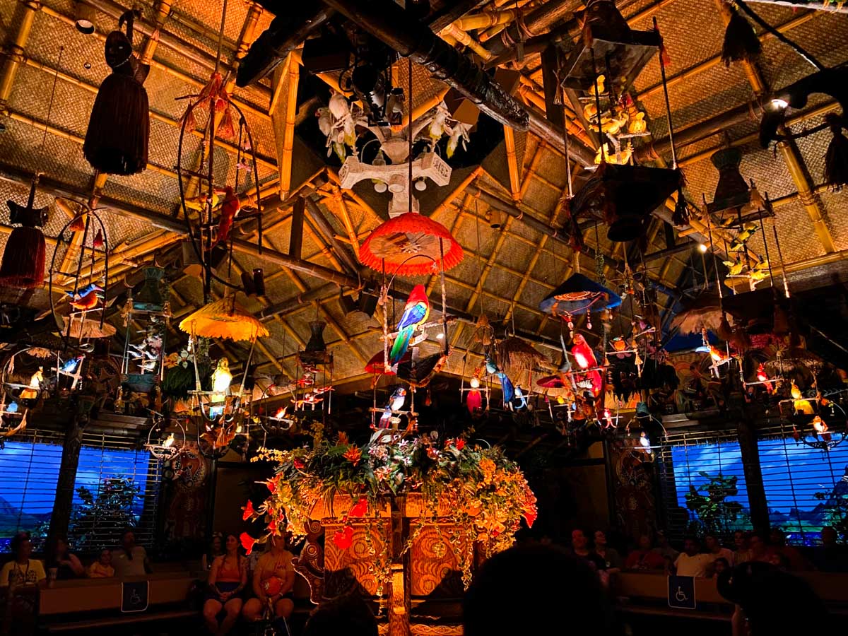 The inside of the tiki room shows animatronic birds singing on the ceiling.