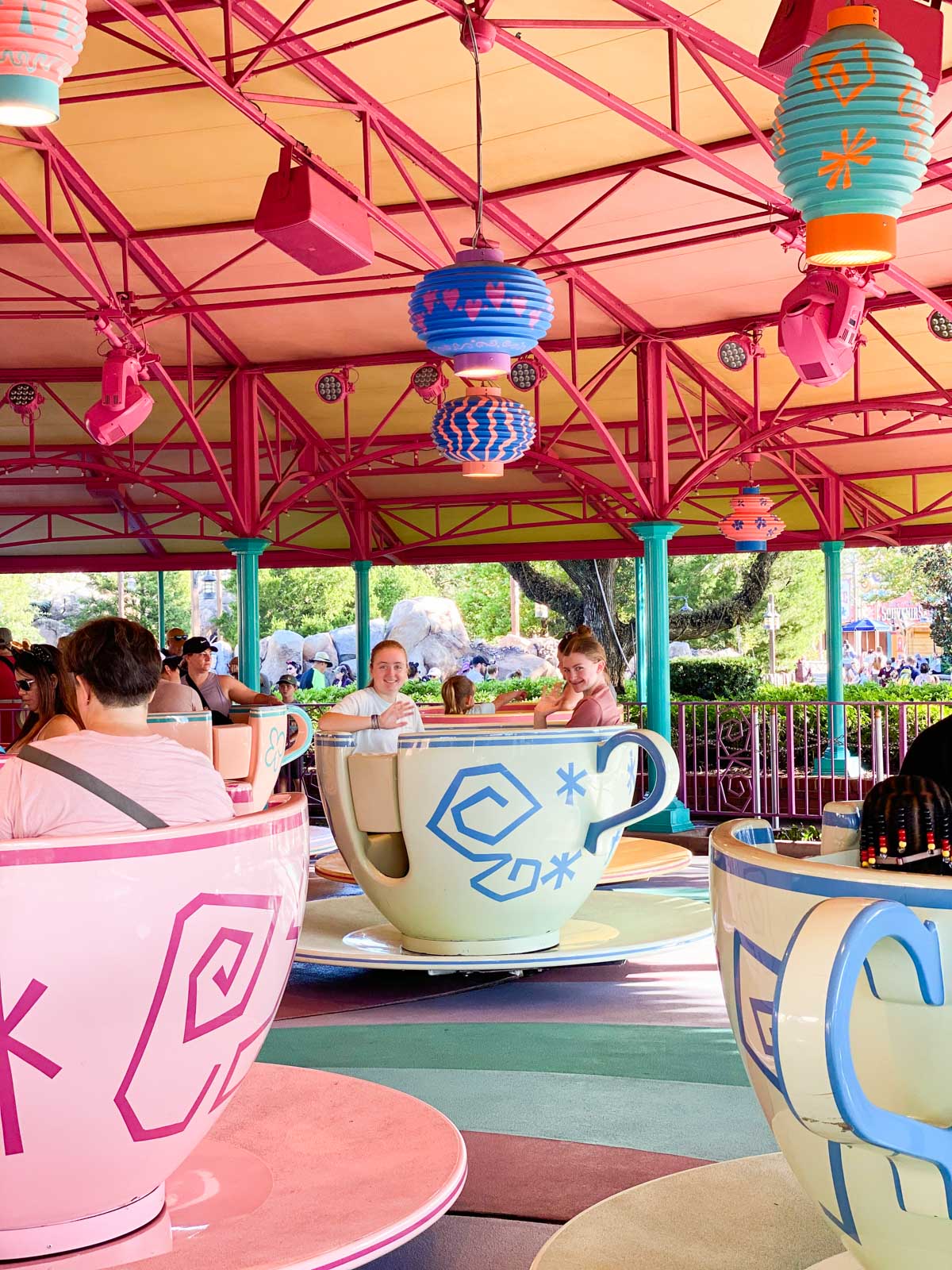 Two girls spin inside a tea cup on the ride.