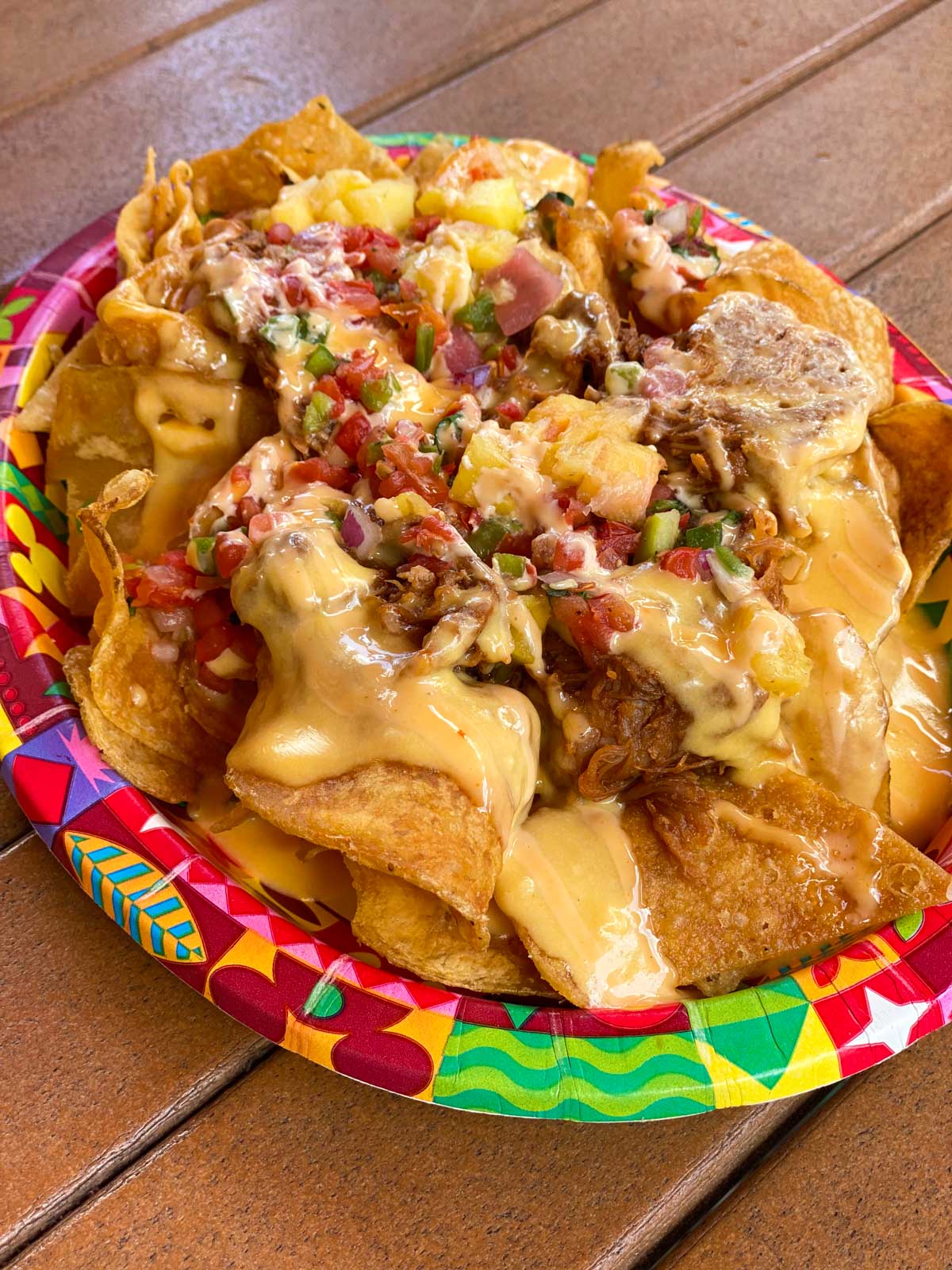 A tray of pork nachos has cheese melted all over the top.