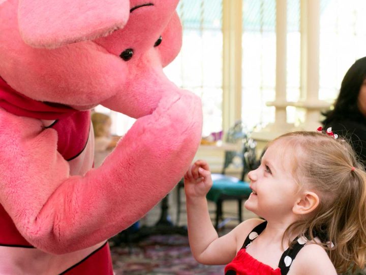 Piglet plays with a young girl wearing a Mickey top.