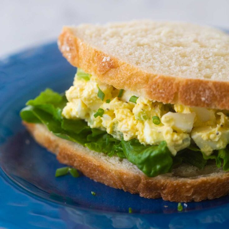 A sandwich with egg salad filling and lettuce.