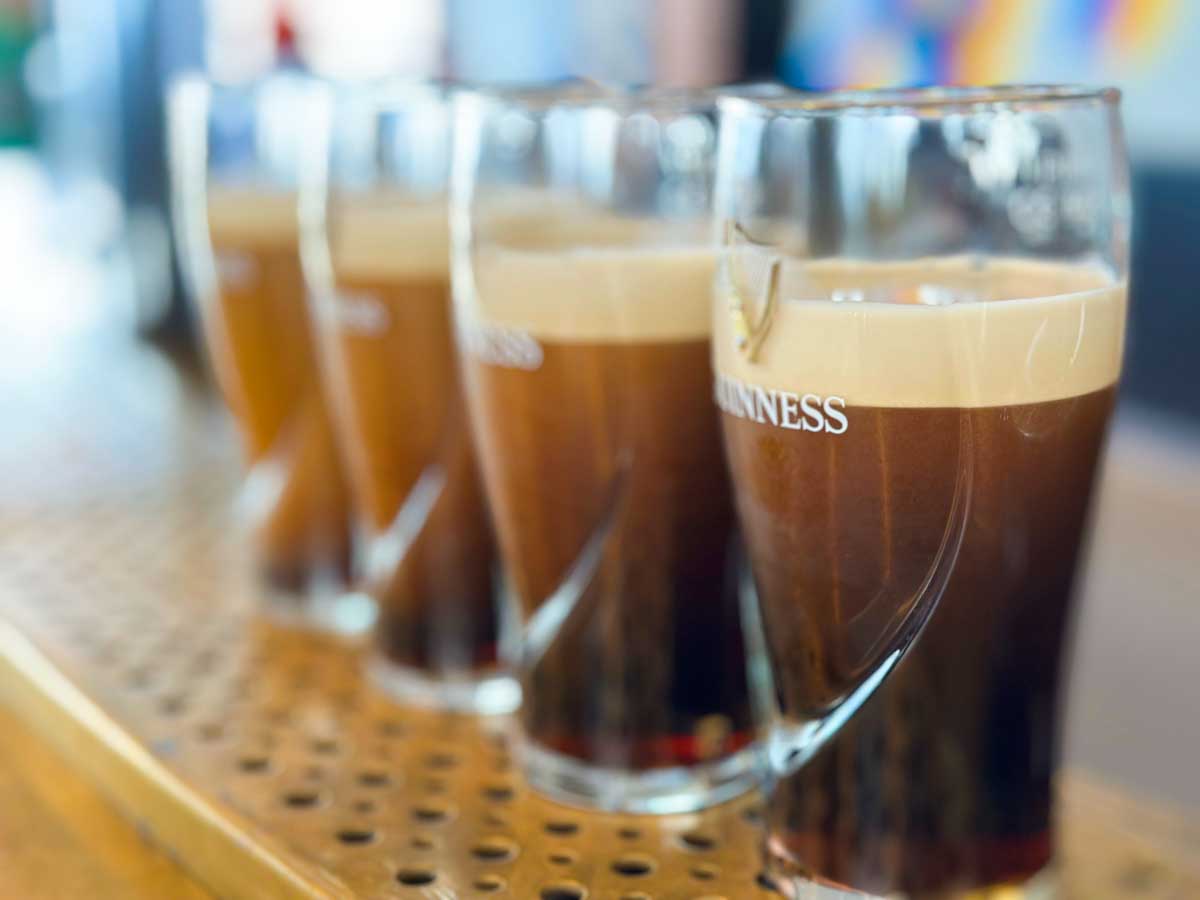 A row of beer glasses filled with Guinness.