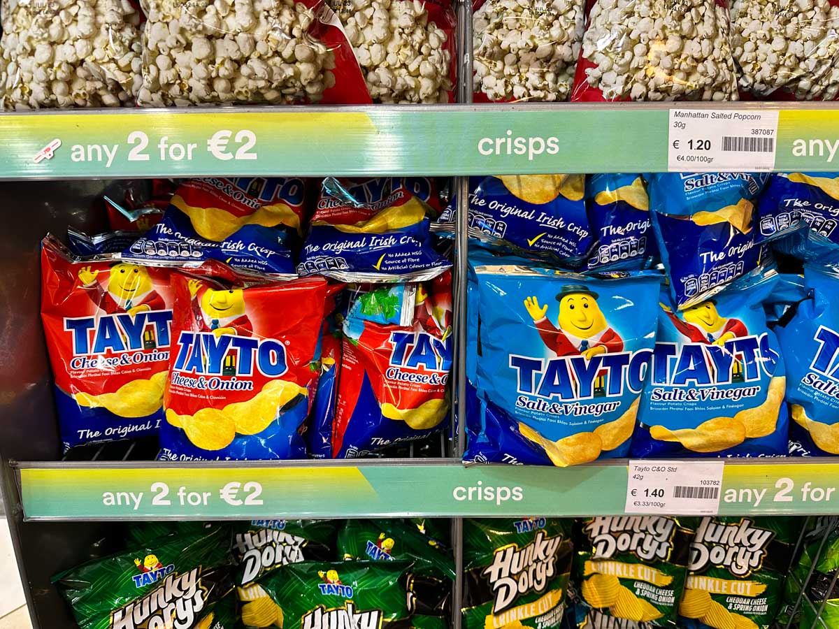A store shelf is filled with Tayto Brand Tayto Chips.