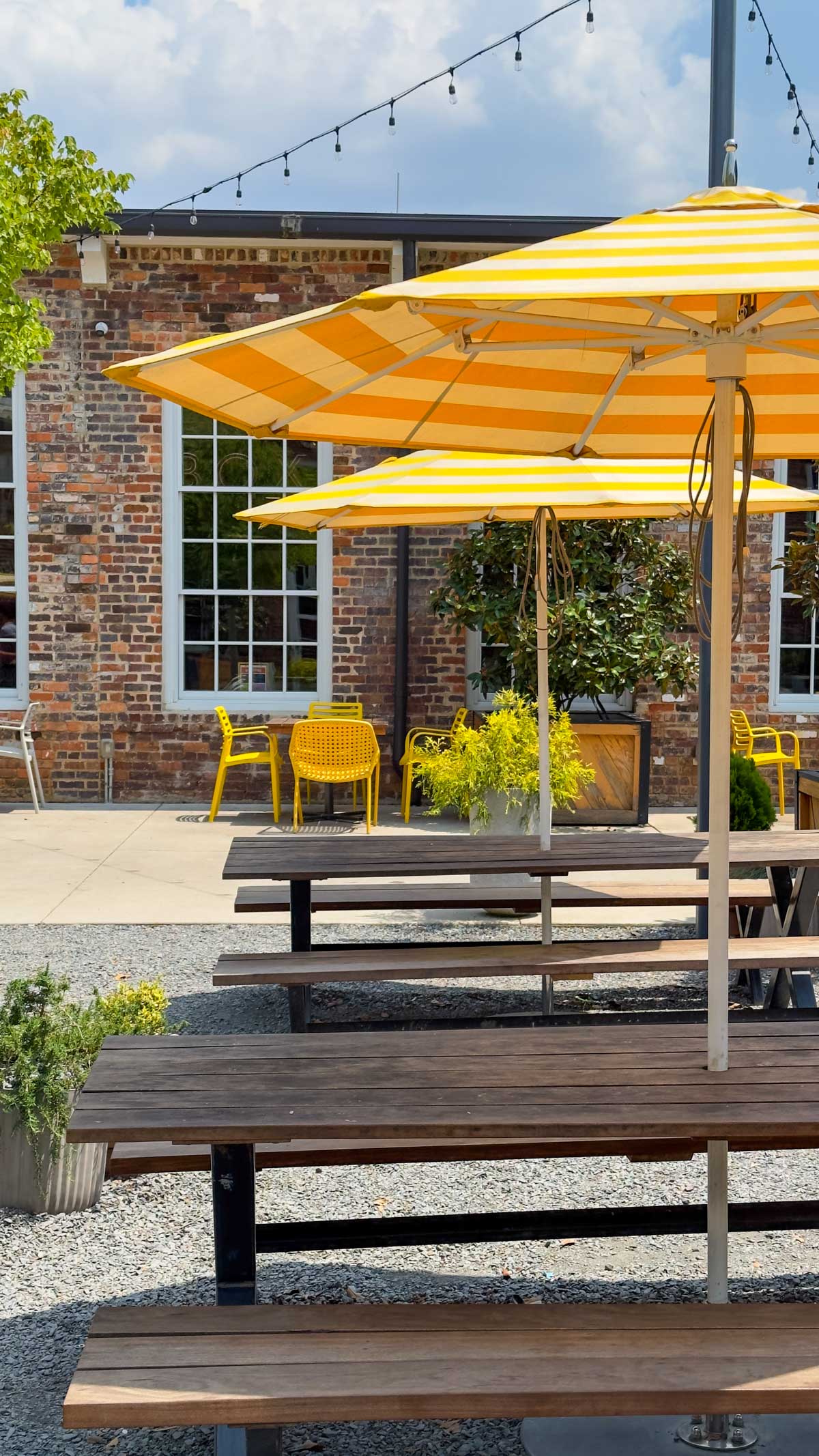 The yellow umbrellas and picnic tables in the outdoor courtyard of Optimist Hall in Charlotte, NC.