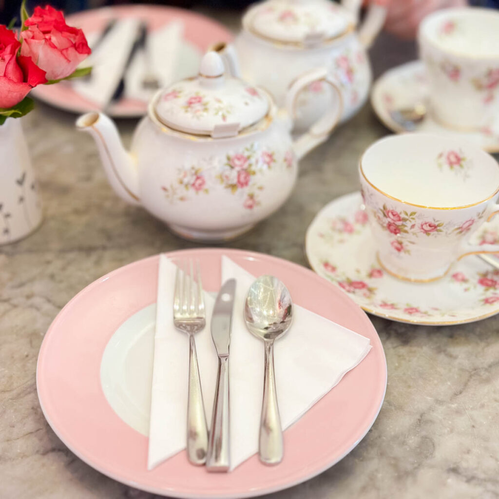 A pink and white tea set with fresh roses is ready for tea time in London.