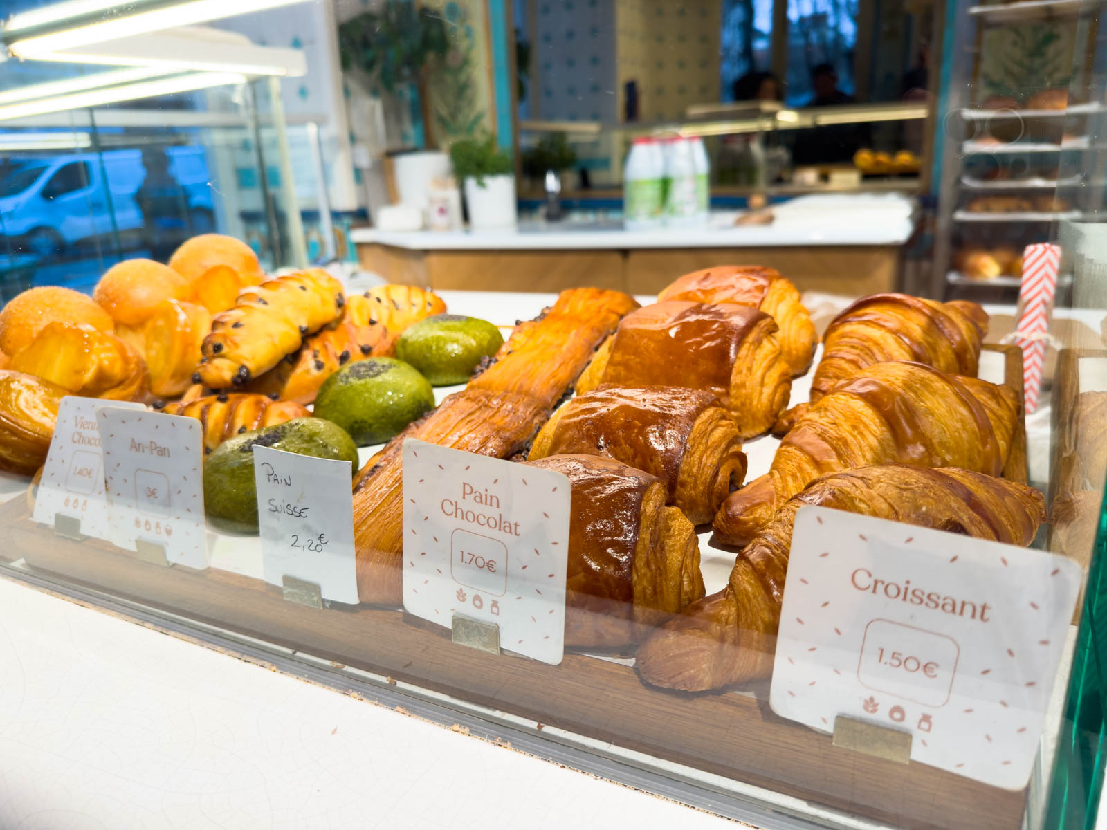 A bakery case has several fresh baked croissants.