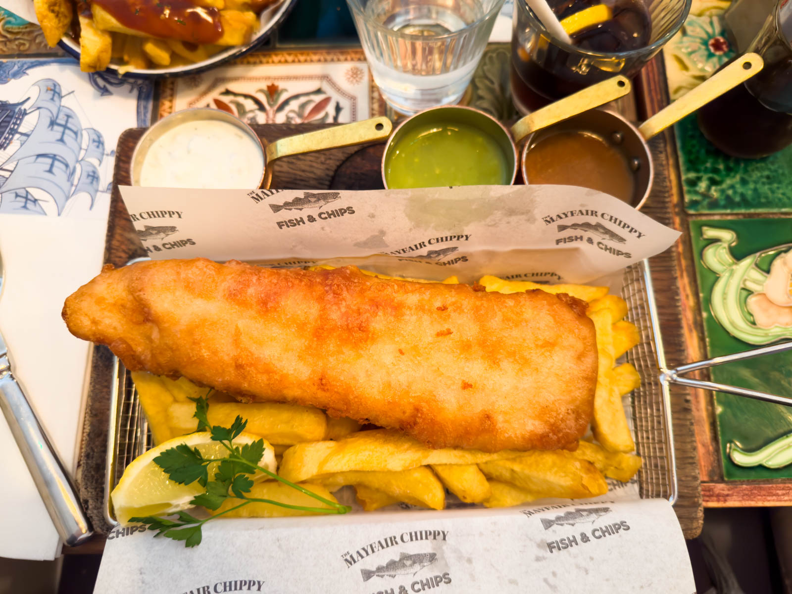 A fried haddock sits on a bed of french fries.