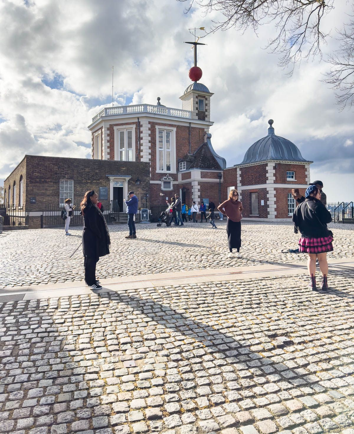 The Greenwich Observatory and Prime Meridian line are seen from outside the gate.