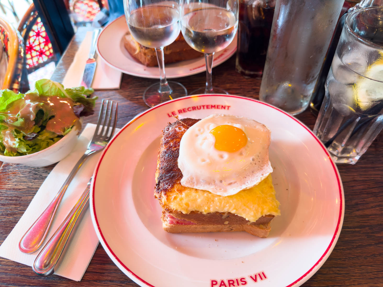 A French sandwich on a plate has a fried egg on top.