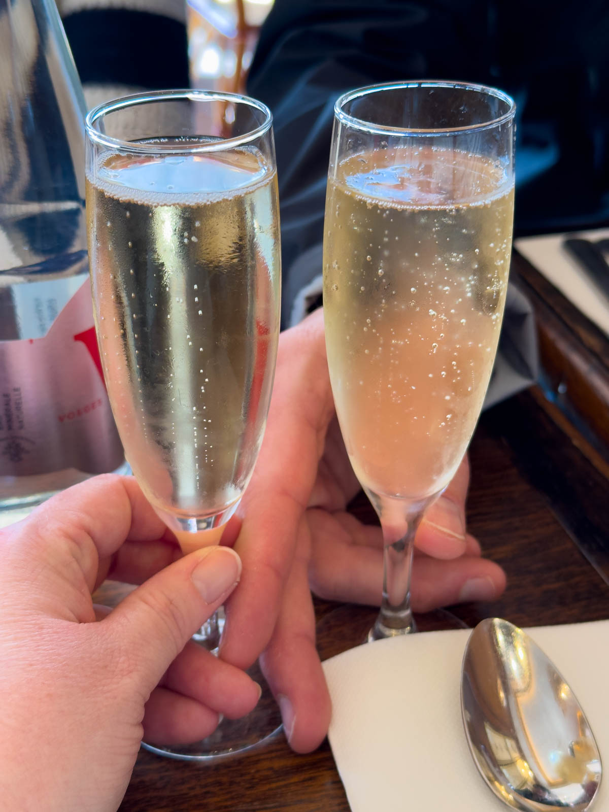 Two glasses of champagne are held in a toast.