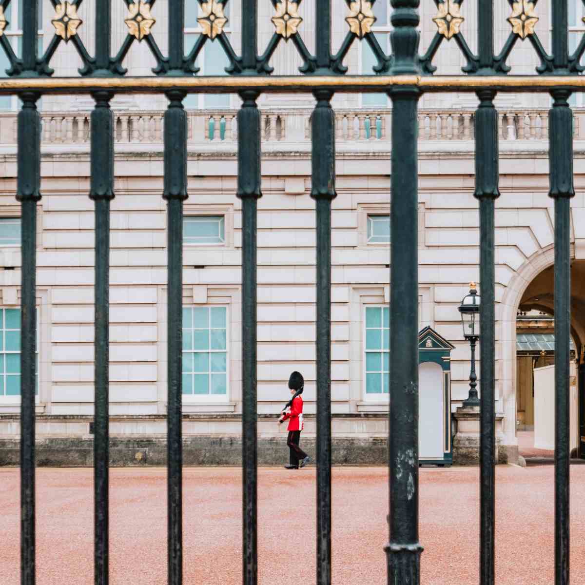 A palace guard paces in front of Buckingham Palace.