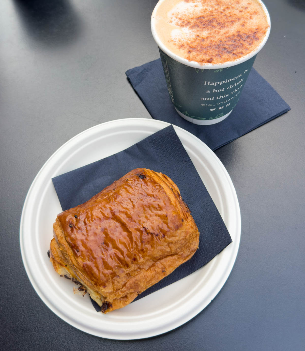 A pastry on a plate next to a cup of coffee.