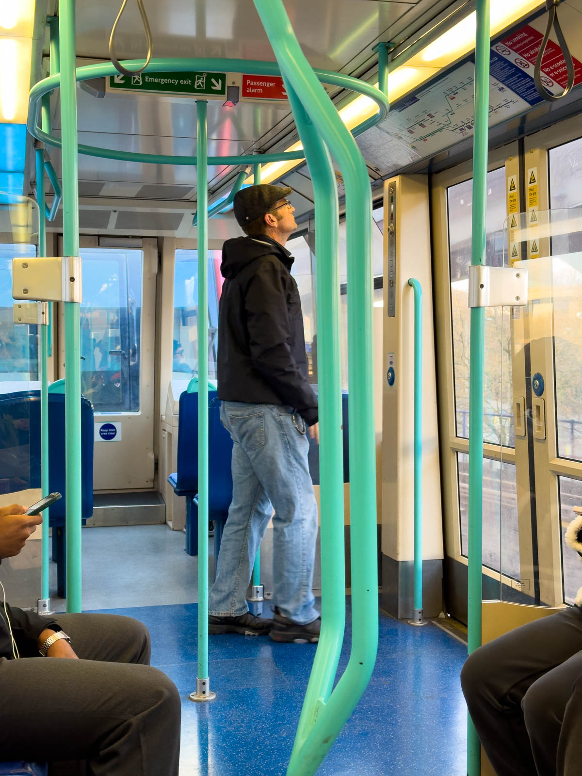 A man looks at the train map while riding the train.
