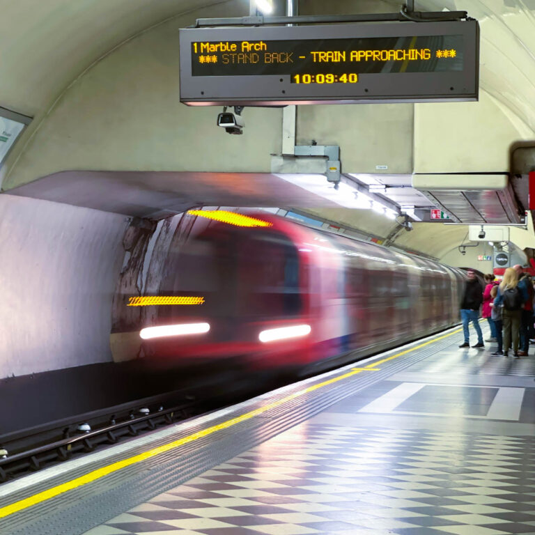 The moving train is blurry in the London Underground station.