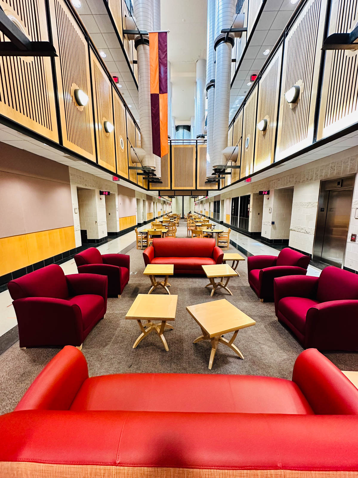 An inside view of Torgersen Hall shows red couches and tables.