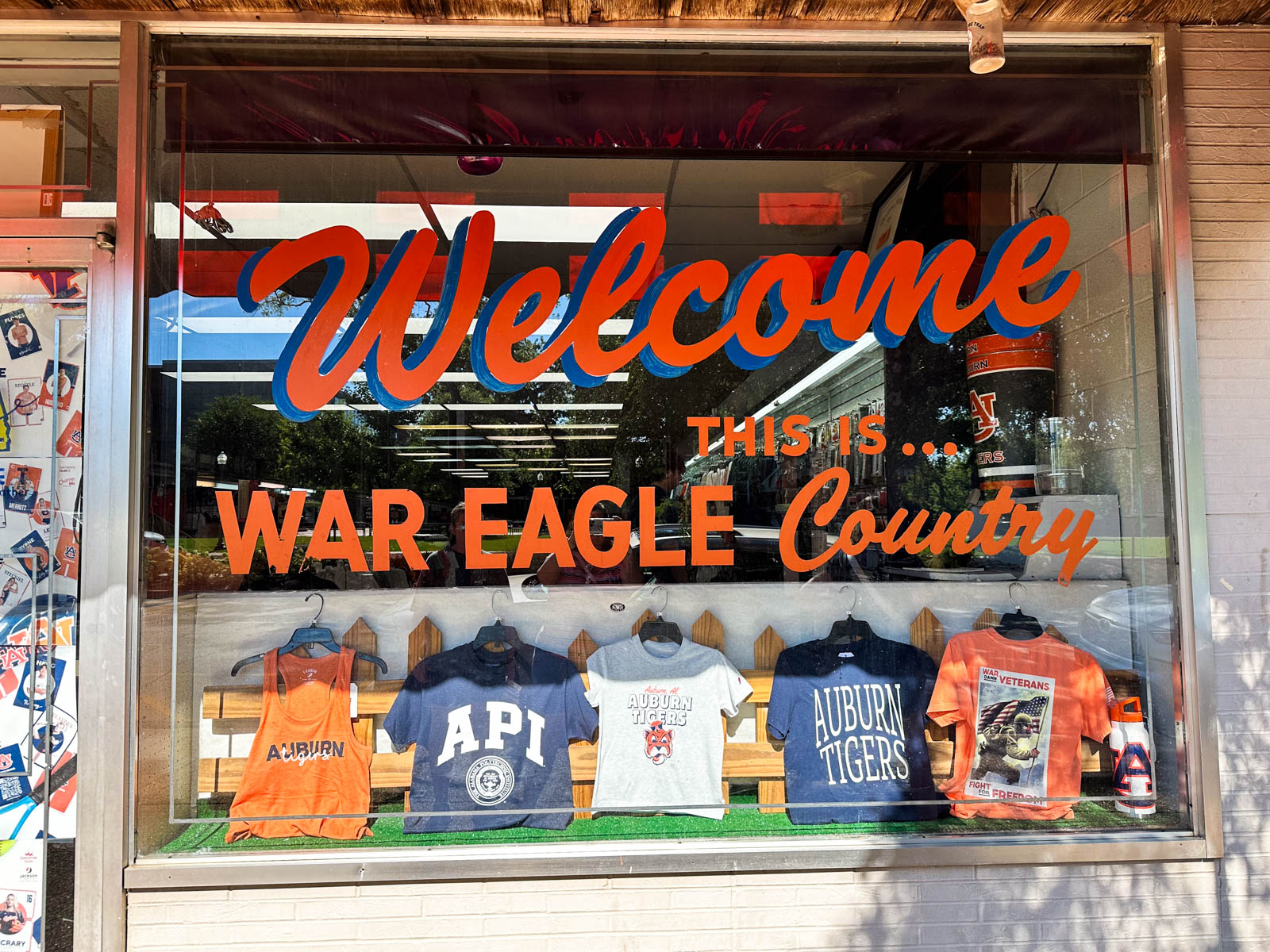 A shop window says "Welcome to War Eagle Country."