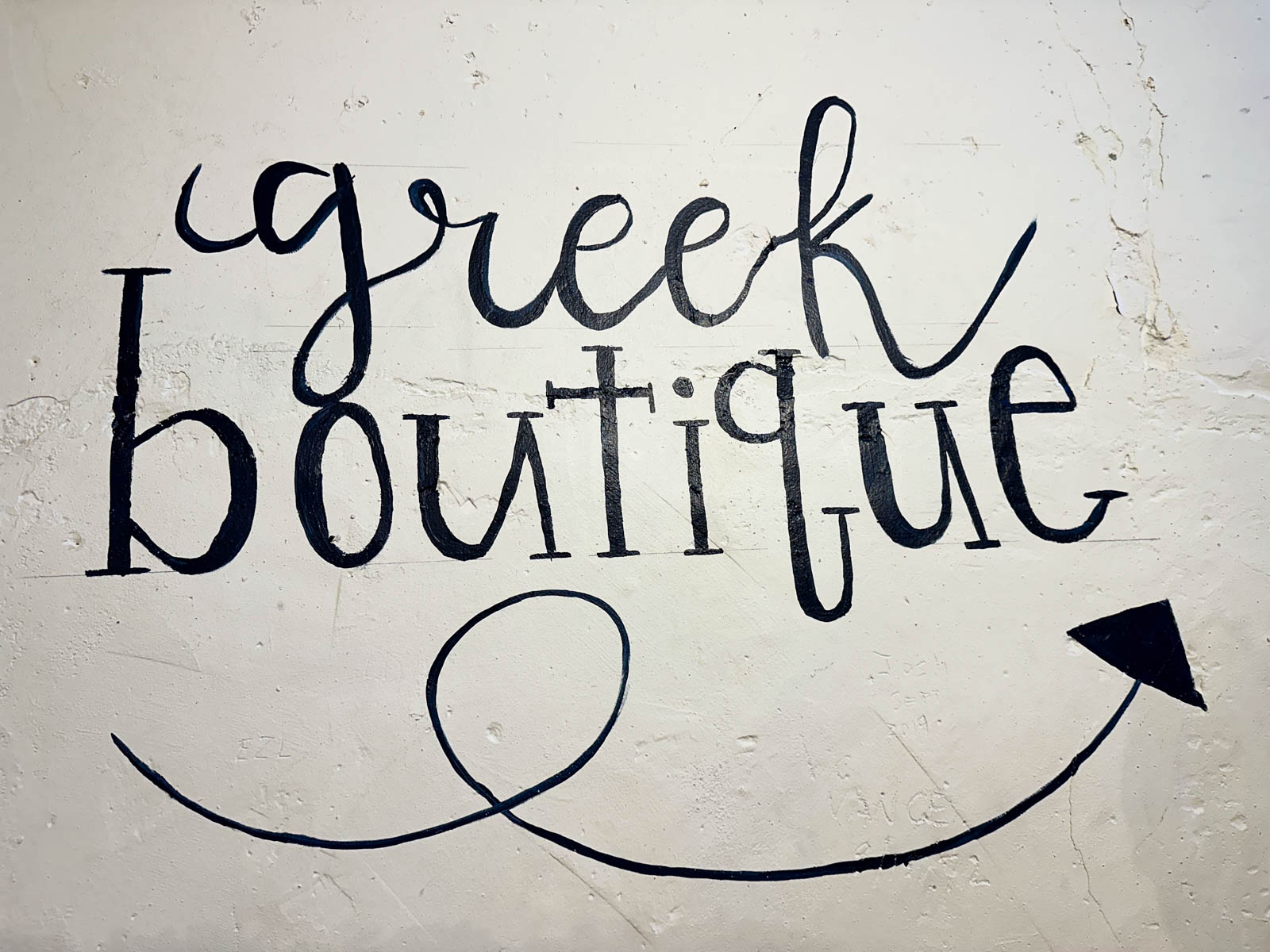 The wall has been painted to say "Greek Boutique"