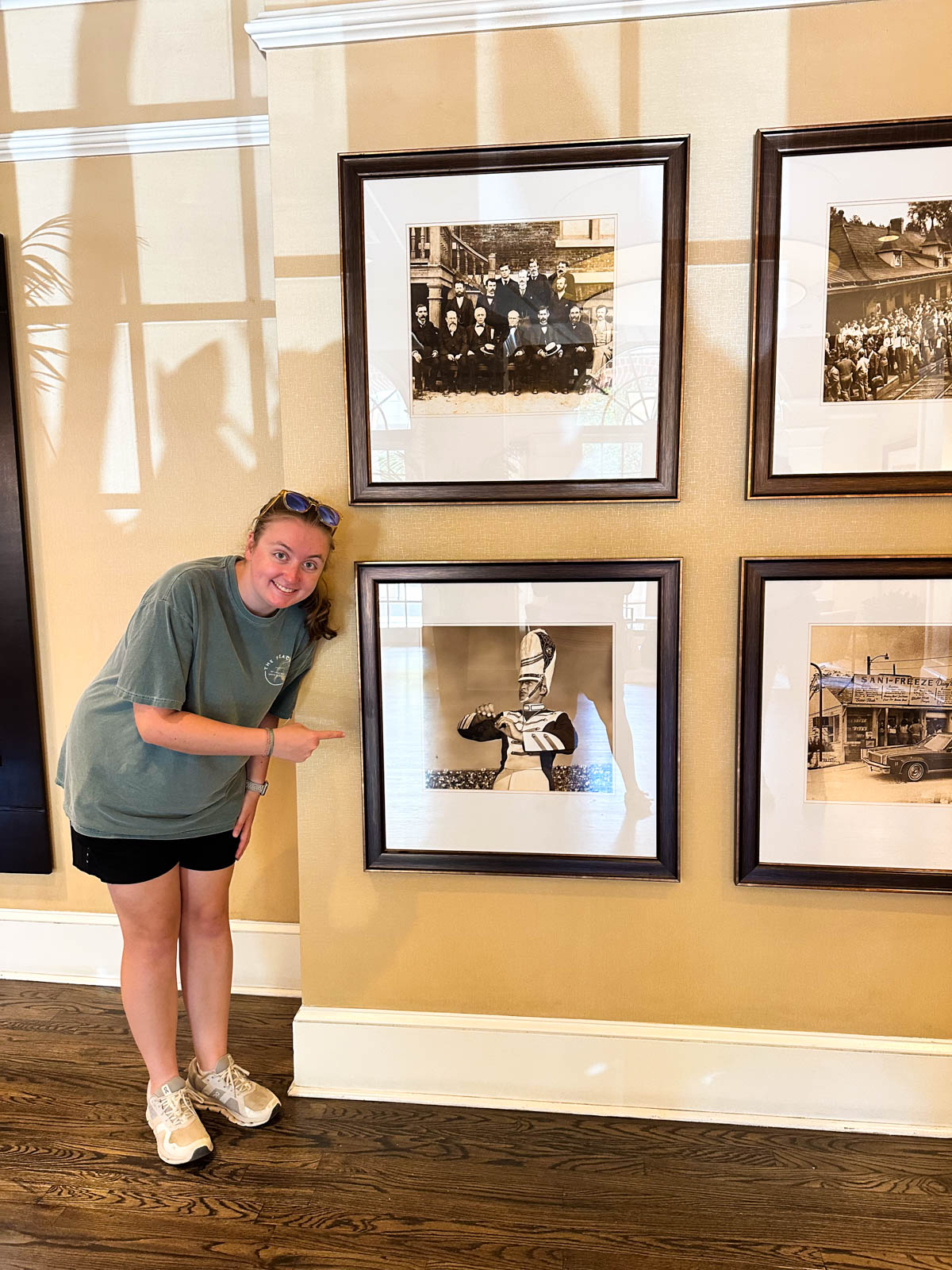 A girl points to a marching band photo on the wall at the hotel.