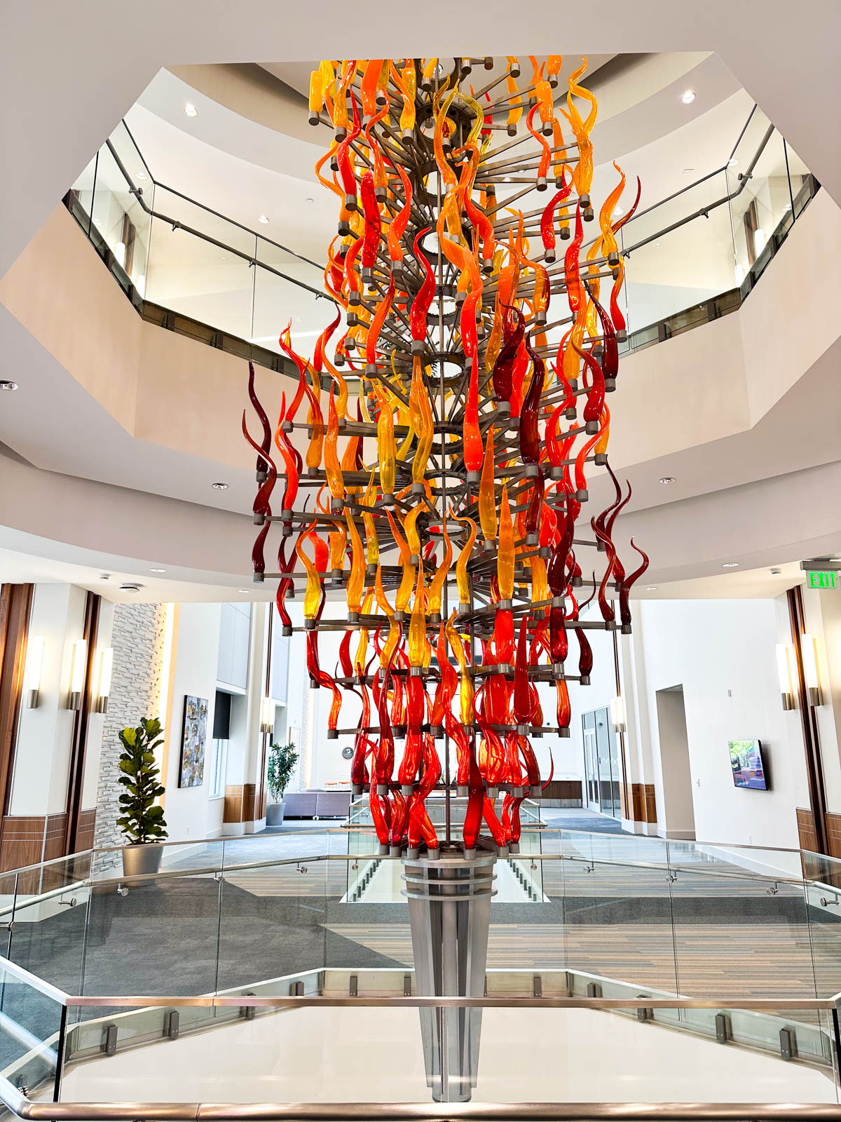 A large glass chandelier that looks like an orange torch inside the visitor's center.