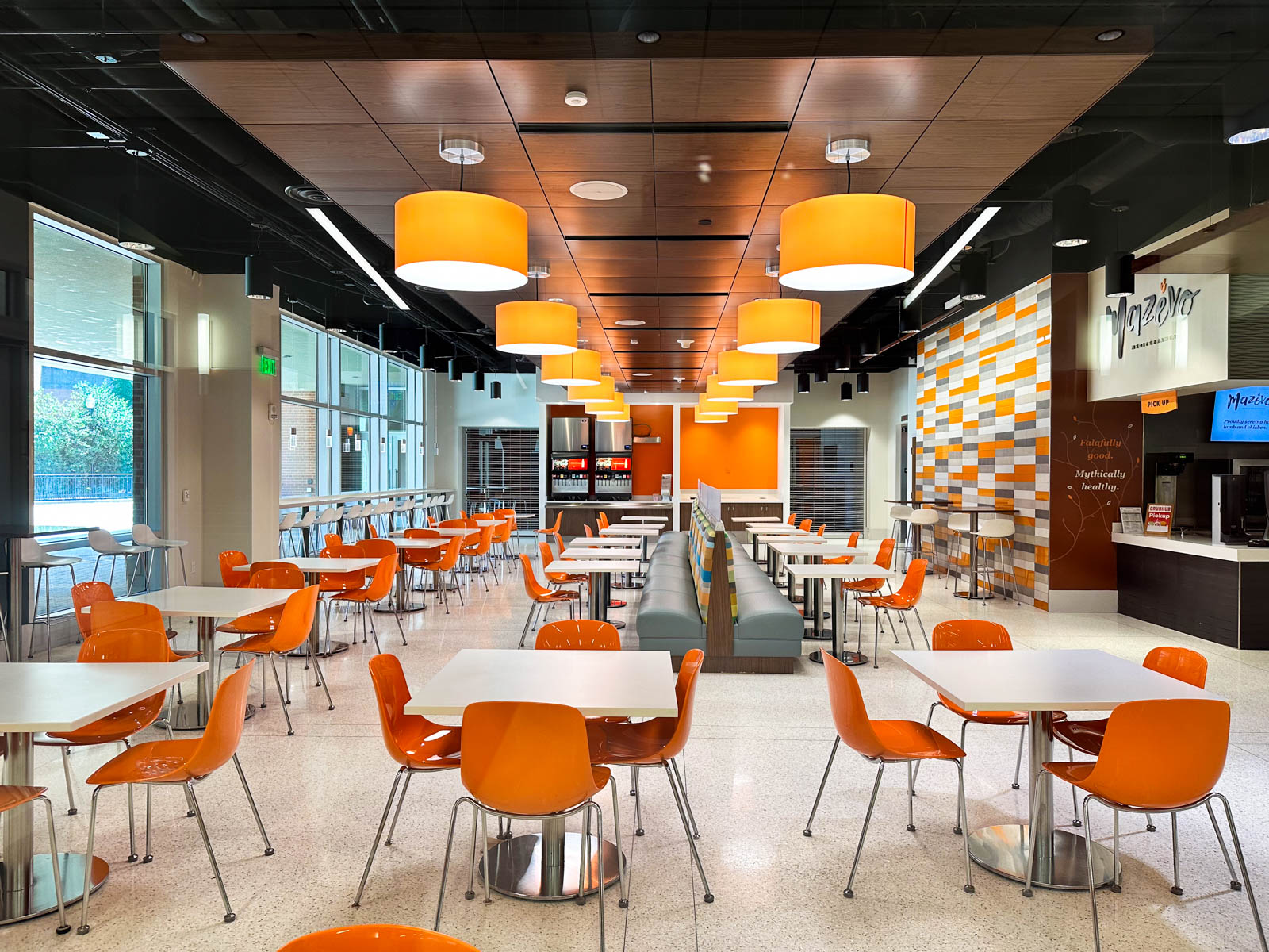 A dining hall with orange chairs at the student union.