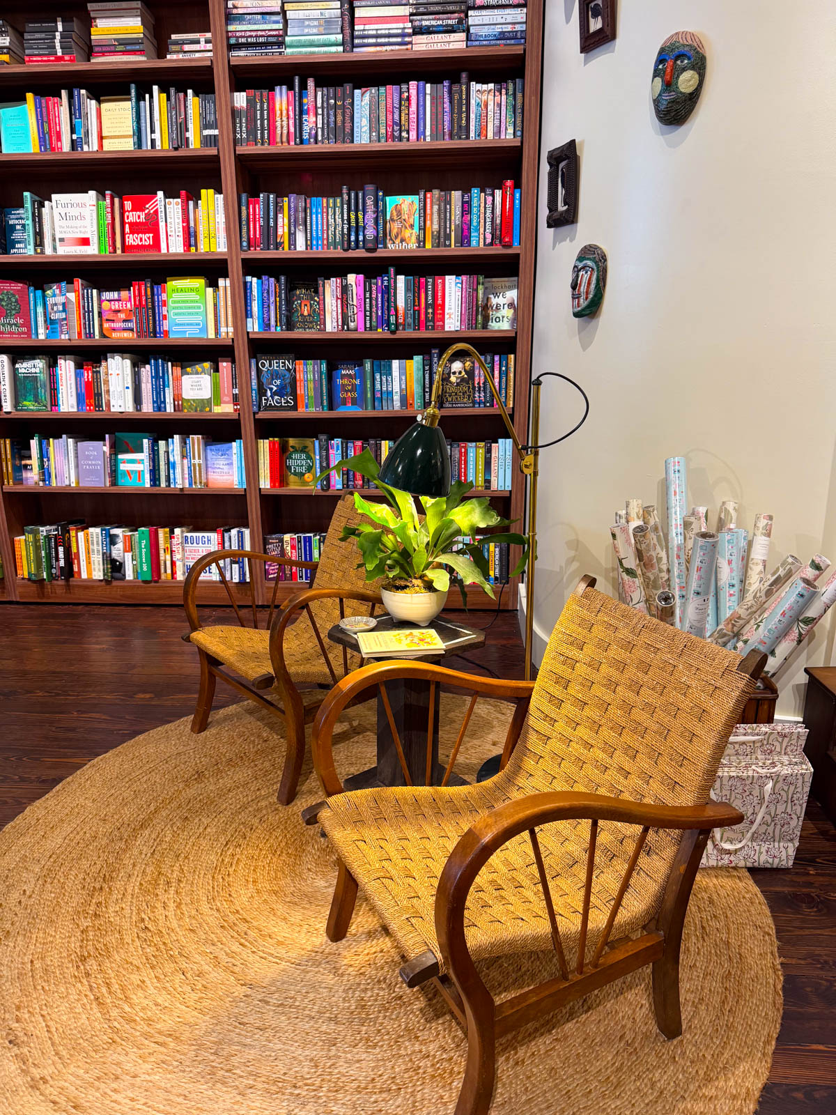 A book shelf with two chairs in front.