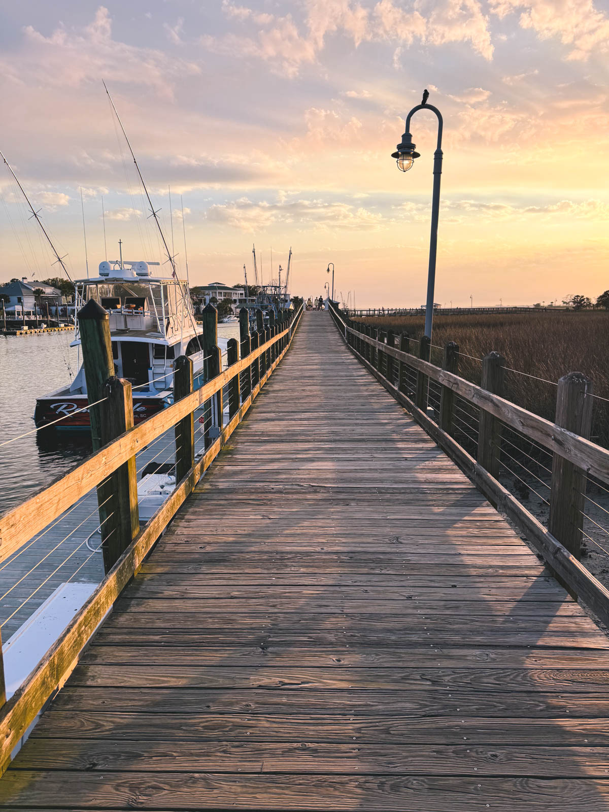 The boardwalk along the water walking into the sunset.