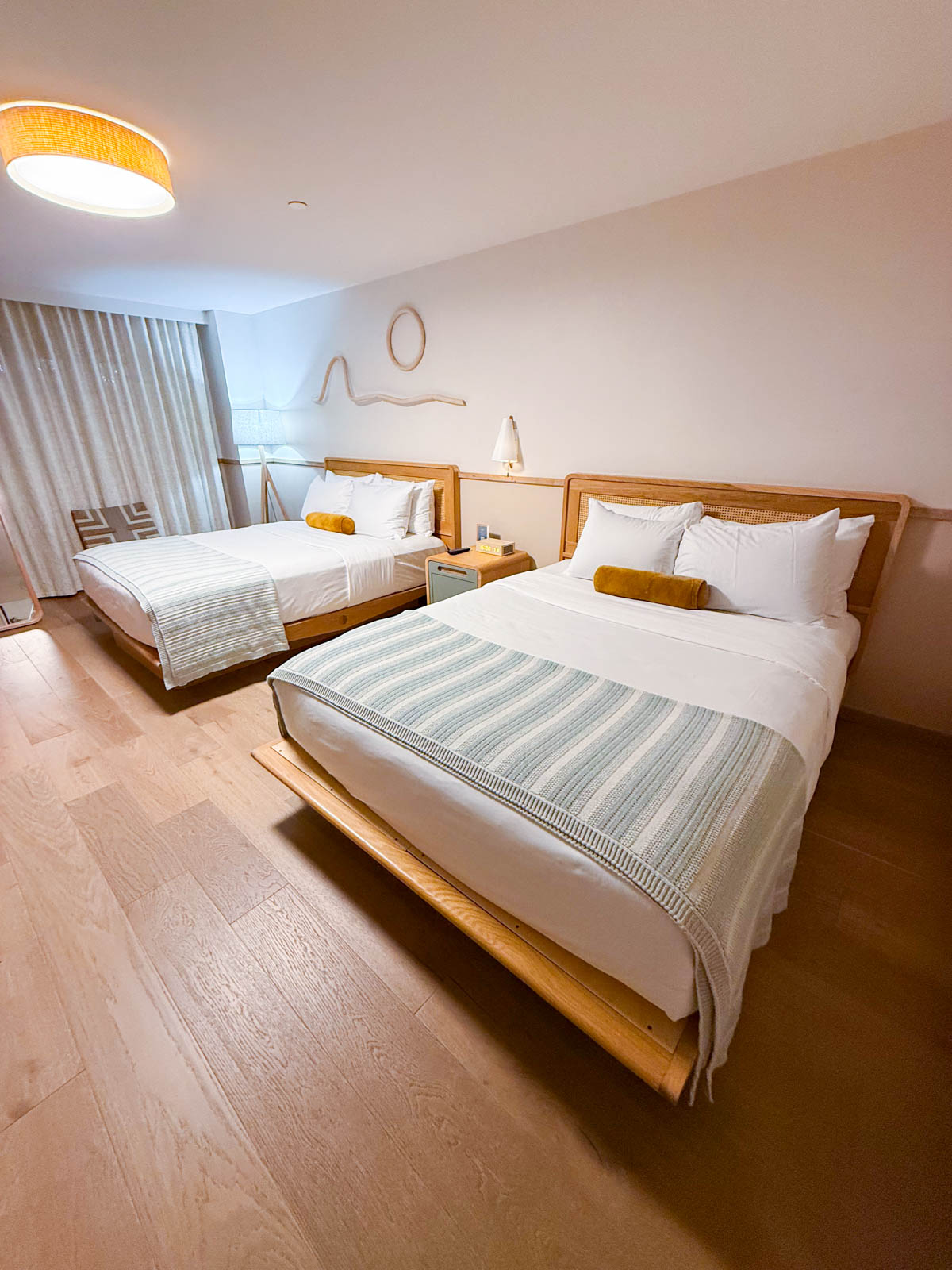 The double queen beds inside a hotel room.