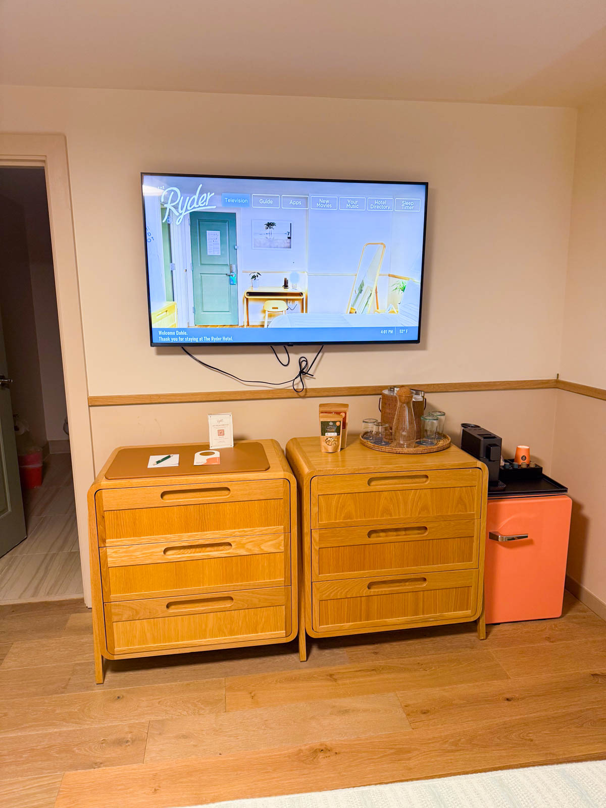 The storage dressers and mini fridge inside the room.
