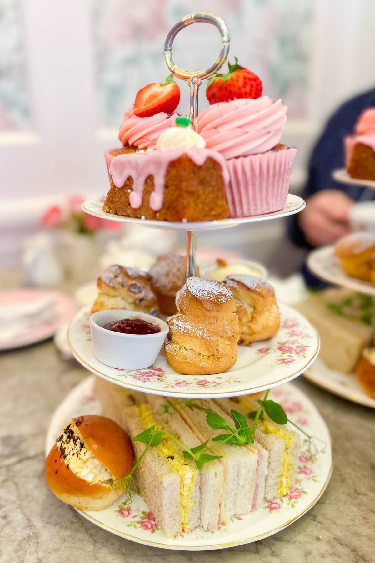 A tiered tea tray filled with pastries and finger sandwiches served at afternoon tea in London.